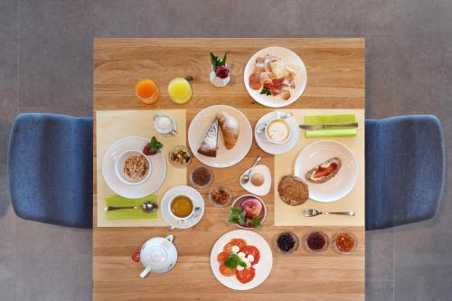 a table with plates of breakfast food on it at Bad St Isidor in Bolzano