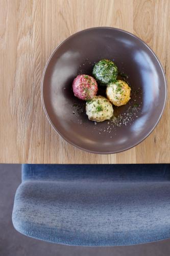 a black plate with four donuts on a table at Bad St Isidor in Bolzano