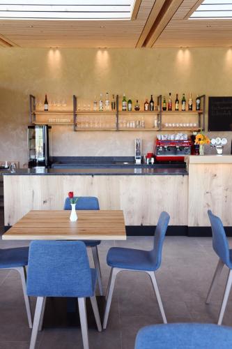 a restaurant with a wooden table and blue chairs at Bad St Isidor in Bolzano