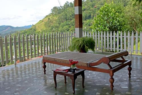 a bench with a vase of flowers on a table at Villa Perpetua in Bandarawela