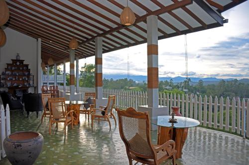 a patio with tables and chairs and a view at Villa Perpetua in Bandarawela