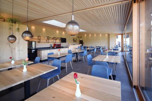 a restaurant with wooden tables and blue chairs at Bad St Isidor in Bolzano