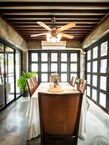 a dining room with a ceiling fan and a table with chairs at Rare, Special Beach Pool Villa in Hua Hin