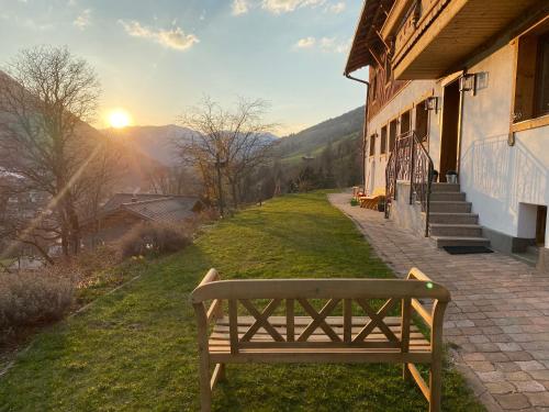 a bench sitting on the grass next to a building at ALM SEASONS Premium Chalet & Studios in Saalbach Hinterglemm