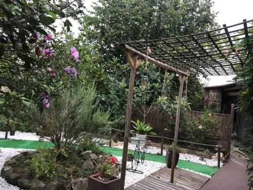 a garden with a wooden pergola and some plants at A Casiña de Esther in Teo