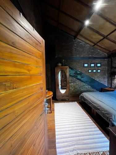 a bedroom with a bed and a wooden door at 1 BR Cozy Apartment in center of Seminyak in Seminyak