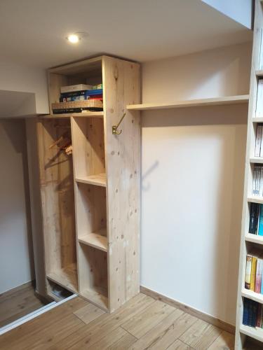 Cette chambre dispose d'un placard avec une porte et des étagères. dans l'établissement Chez Camille et Lolo, à La Mure