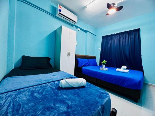 two beds in a room with blue walls at Comfy 1BR for 3pax Malaysian guest only Walk to USM Ideal for Budget in Gelugor