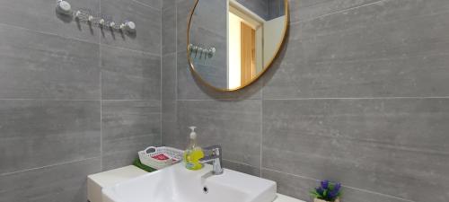 a bathroom with a sink and a mirror at Jia嘉 Homestay - Kuching Riverine Diamond Resort in Kuching