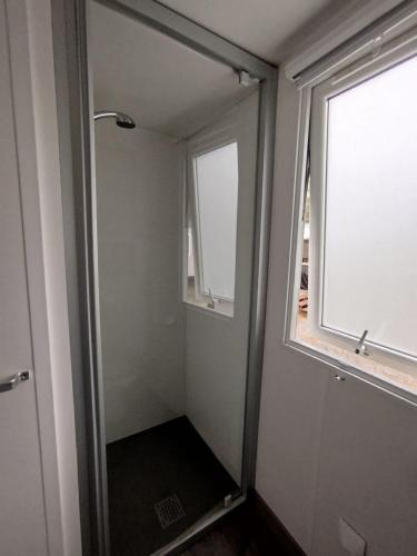 La salle de bains est pourvue d'une douche à l'italienne et d'une fenêtre. dans l'établissement MH 353 LUMINOSA 3chambres et 2 salles de bains dans camping 4 étoiles, à Saint-Julien-en-Born