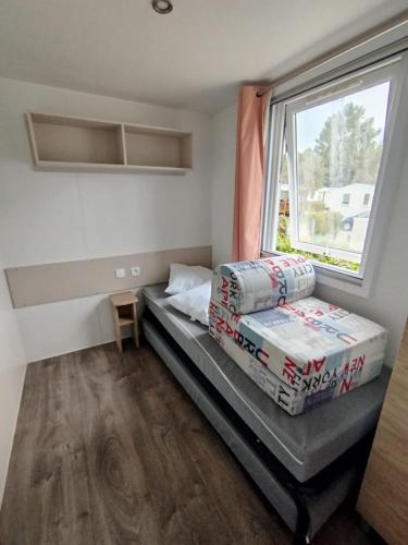 une petite chambre avec un lit et une fenêtre dans l'établissement MH 353 LUMINOSA 3chambres et 2 salles de bains dans camping 4 étoiles, à Saint-Julien-en-Born