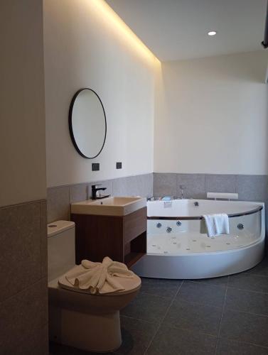 a bathroom with a tub and a toilet and a sink at The Richer Ratchaburi in Ratchaburi