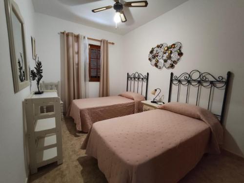 a bedroom with two beds and a ceiling fan at Sea Carnation Well Located, Pool & Terrace in Los Pocillos