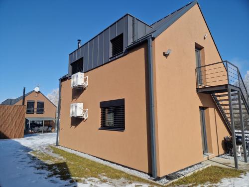 a building with a staircase on the side of it at Relax Vila Lipno- apartmán v podkroví u pláže Windy Point in Černá v Pošumaví