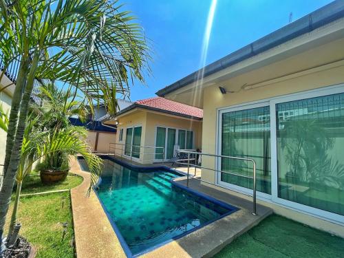 a villa with a swimming pool in front of a house at 2 BR villa with private swimming pool and jacuzzi 350m from beach in Pattaya South