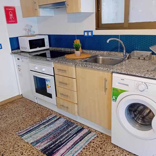 a kitchen with a sink and a washing machine at María PLAYA BRISA NG in Peniscola