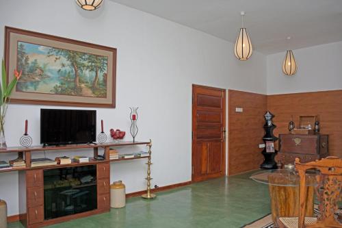 a living room with a flat screen tv on a wall at Villa Perpetua in Bandarawela