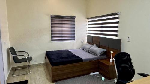a bedroom with a bed and a desk and a chair at HomeStay in Ikuata