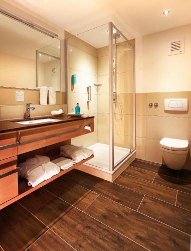 a bathroom with a shower and a sink and a toilet at Naturparkhotel Adler in Wolfach