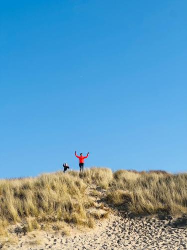 a person standing on top of a sand dune at Zeeuws Ibiza huisje in Kamperland
