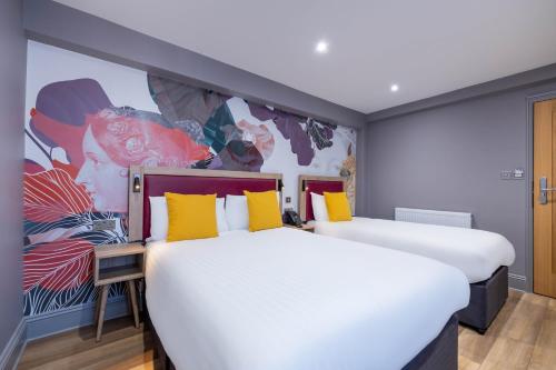 two beds in a room with a mural at Comfort Inn Edgware Road W2 in London