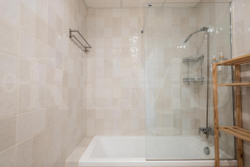 un baño con ducha y bañera en Beachside escape with parking and pool REMS, en Torremolinos