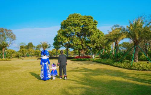 a man and a woman and a child standing in a park at Beihai Marriott Resort in Beihai