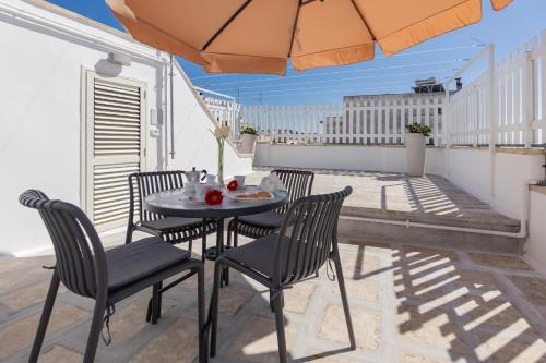 a table and chairs on a balcony with an umbrella at Casa vacanze Claudio e Maria Grazia in Parabita