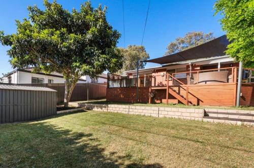 a house with a fence and a yard at Inner south comfort house in Narrabundah