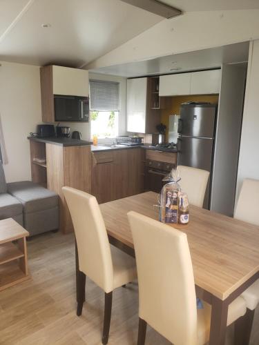 - une cuisine avec une table à manger en bois et des chaises dans l'établissement Mobil-home 3 chambres Pont-Aven, à Pont-Aven
