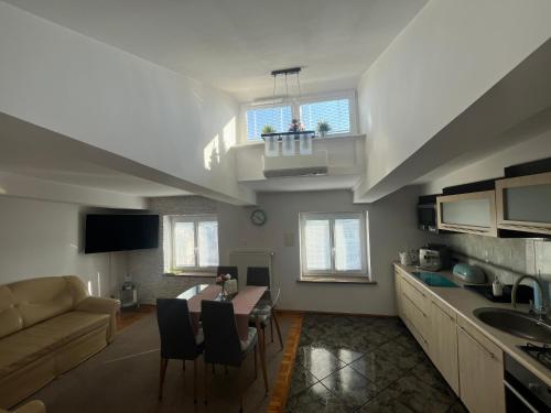 Una cocina y una sala de estar con un sofá y una mesa. en Marszałkowska Apartament RM HOUSE, en Varsovia