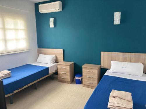 two beds in a room with blue walls at Amaca in Mijas Costa