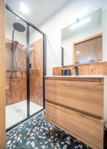 une salle de bain avec une douche, un lavabo et un miroir dans l'établissement La voyageuse, à Tournus