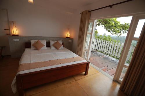 a bedroom with a bed and a sliding glass door at Villa Perpetua in Bandarawela