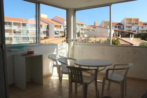 d'un balcon avec une table, des chaises et des fenêtres. dans l'établissement PORT-LEUCATE - PROXIMITE PLAGE - 4 personnes, à Leucate-Plage