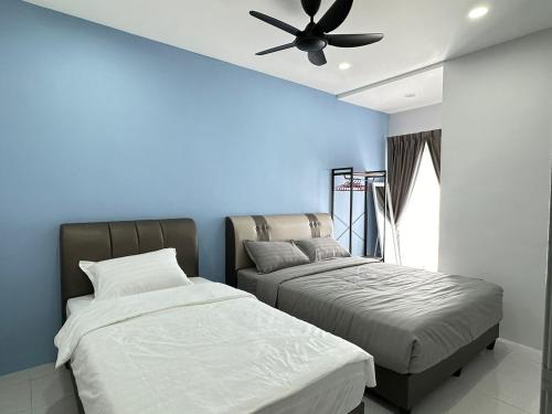 a bedroom with two beds and a ceiling fan at Forever Green cameron in Brinchang