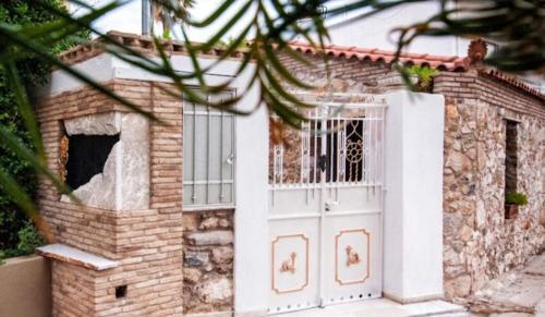 a small brick house with a white door at Home4U Κερατέα apt5, just 17Km from airport in Keratea