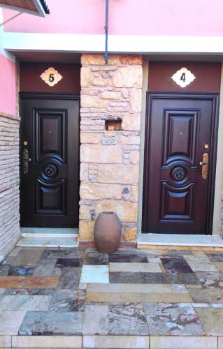 two black doors on the side of a building at Home4U Κερατέα apt5, just 17Km from airport in Keratea