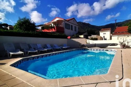 une piscine dans une villa avec une maison dans l'établissement Appartement T2 Le Clos Fleuri, au Lavandou
