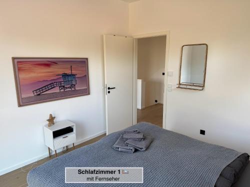 a bedroom with a bed and a mirror on the wall at Moderne Doppelhaushälfte mit 3 SZ in der Nähe vom Scharmützelsee-seperat&naturnah in Wendisch Rietz