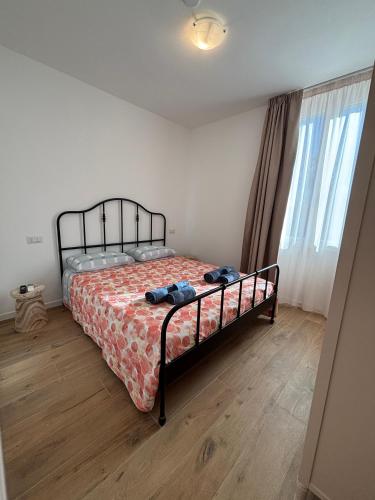 a bedroom with a bed with a comforter on it at MARIS Apartments & Bedrooms in Alghero