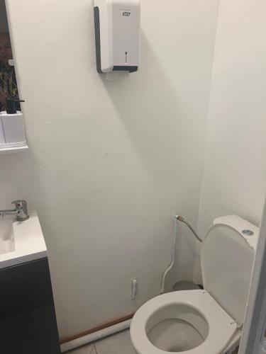 a white bathroom with a toilet and a sink at Le Manteau Bleu in Béziers