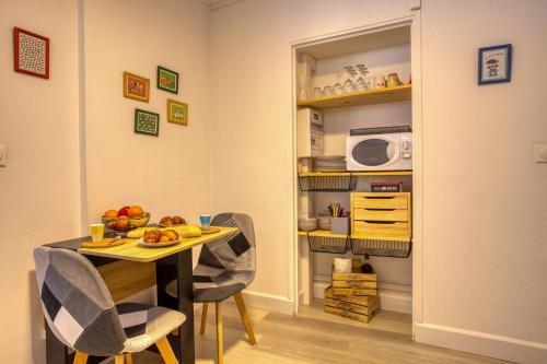 une salle à manger avec une table et un four micro-ondes dans l'établissement 2 pièces climatisé, 100m du centre, 