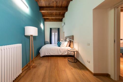 a bedroom with a bed and a blue wall at Suite Deluxe in Palazzo Storico - Centro Sassari - Appartamento Porto Vecchio in Sassari