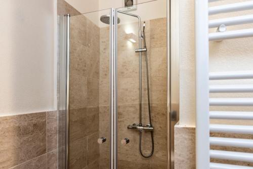 a shower with a glass door in a bathroom at Suite Deluxe in Palazzo Storico - Centro Sassari - Appartamento Porto Vecchio in Sassari