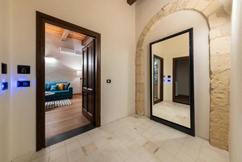 a hallway with a mirror and a living room at Suite Deluxe in Palazzo Storico - Centro Sassari - Appartamento Porto Vecchio in Sassari