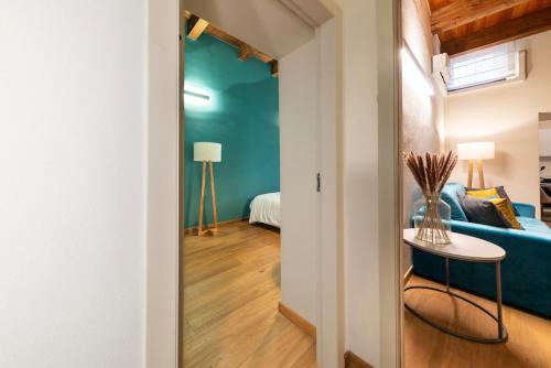a living room with a blue couch and a table at Suite Deluxe in Palazzo Storico - Centro Sassari - Appartamento Porto Vecchio in Sassari