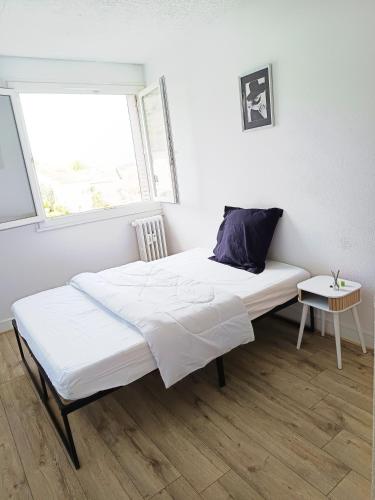 un lit blanc dans une chambre avec une fenêtre dans l'établissement Chambre avec lit double, à Besançon