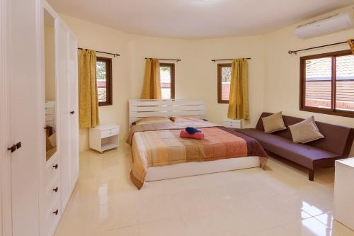 a bedroom with a bed and a couch at Villa Marcello in Pattaya South