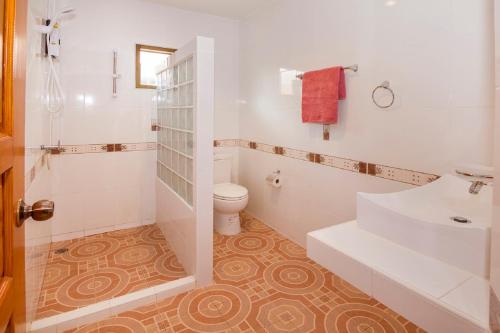 a white bathroom with a toilet and a sink at Villa Marcello in Pattaya South